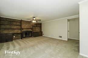 Greensboro house for rent - a living room with a brick fireplace and a ceiling fan