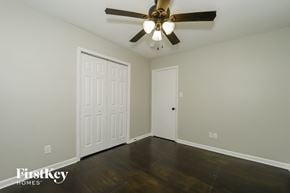 Greensboro house for rent - a bedroom with wood floors and a ceiling fan
