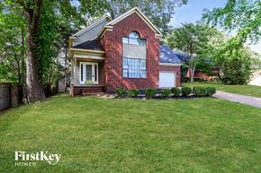 Memphis house for rent - the front of a brick house with a lawn and trees