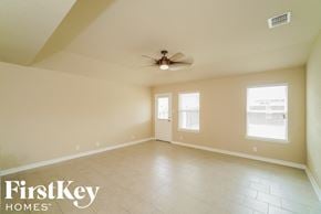 San Antonio house for rent - A spacious room with a ceiling fan and two windows.