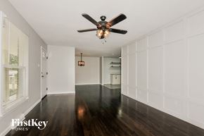 Saint Charles house for rent - a living room with white walls and wood floors and a ceiling fan