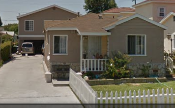 Lawndale apartment for rent - A white picket fence separates a driveway from a house.