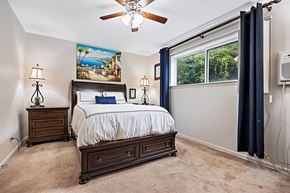 Bensenville apartment for rent - A bedroom with a bed, nightstands, and a ceiling fan.