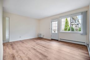 Des Plaines apartment for rent - A room with a window overlooking a tree and a building.