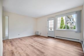 Des Plaines apartment for rent - A room with a window overlooking a tree and a building.