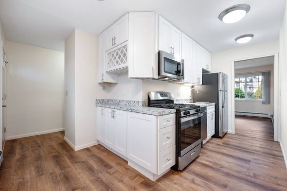 Des Plaines apartment for rent - A kitchen with white cabinets and a granite countertop.