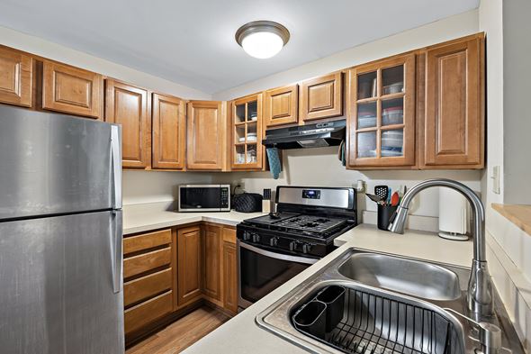Worth apartment for rent - A kitchen with wooden cabinets and stainless steel appliances.