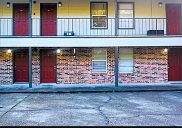 Hammond apartment for rent - a building with three red doors and a sidewalk