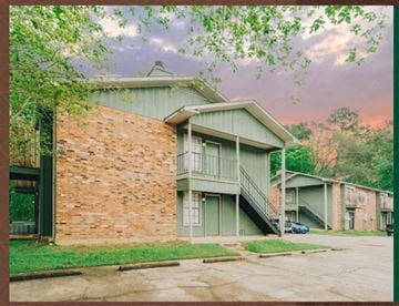 Hammond apartment for rent - a green house with a brick wall and a balcony