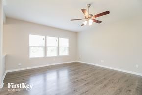 Kernersville house for rent - A spacious room with a ceiling fan and wooden flooring.