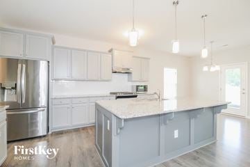 Kernersville house for rent - A kitchen with a stainless steel refrigerator and a white countertop.