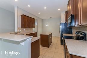 Middleburg house for rent - a kitchen with wood cabinets and white counter tops and a black refrigerator