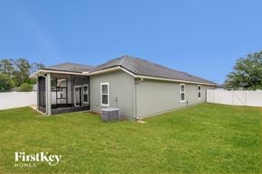 Middleburg house for rent - a backyard with a green house and a grass lawn