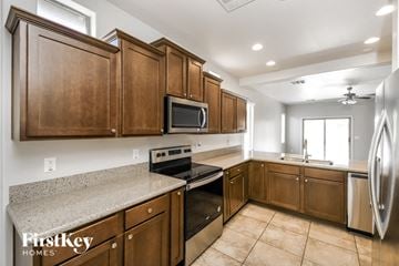 San Tan Valley house for rent - A kitchen with wooden cabinets and a granite countertop.
