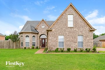 Arlington house for rent - a brick house with a green lawn and a wooden fence