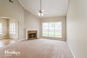Arlington house for rent - an empty living room with a fireplace and a ceiling fan