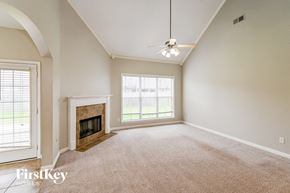 Arlington house for rent - an empty living room with a fireplace and a ceiling fan