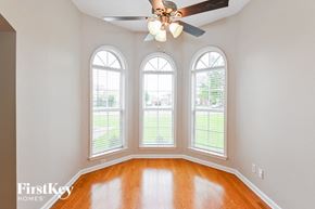 Arlington house for rent - an empty living room with three windows and a ceiling fan