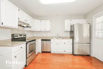 Greensboro house for rent - A kitchen with white cabinets and a stainless steel refrigerator.