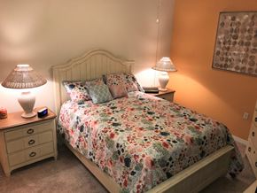 Bradenton house for rent - A bedroom with a floral bedspread and two lamps.