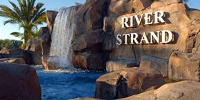 Bradenton house for rent - A waterfall flows into a pool in front of a rock with the words "River Strand" written on it.