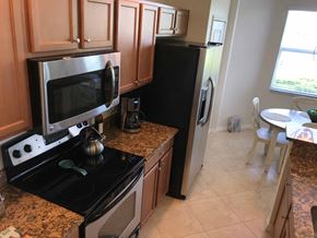 Bradenton house for rent - A kitchen with black appliances and granite countertops.