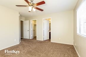 Mesa house for rent - a bedroom with a ceiling fan and a carpeted floor