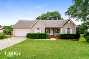 Loganville house for rent - a white house with a lawn and a driveway