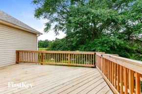 Loganville house for rent - a backyard deck with trees and a house