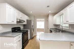 Lawrenceville house for rent - a kitchen with white cabinets and a black stove and refrigerator