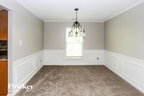 Charlotte house for rent - an empty dining room with white wainscoting and a window