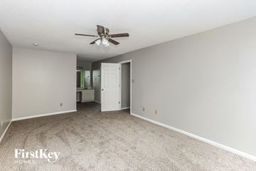 Charlotte house for rent - a spacious living room with carpet and a ceiling fan