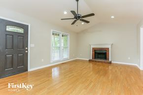 Powder Springs house for rent - A room with a fireplace and a ceiling fan.