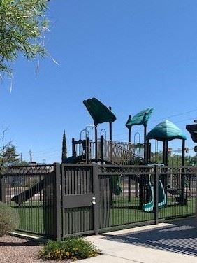 Sierra Vista apartment for rent - A playground with a green slide and a black fence.