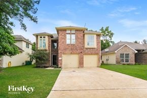 Conroe house for rent - a large brick house with a garage and a driveway