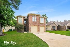 Conroe house for rent - a house with a driveway and a lawn
