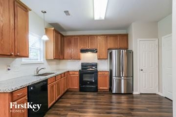 Conroe house for rent - a kitchen with wooden cabinets and a stainless steel refrigerator