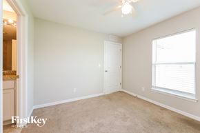 Cape Coral house for rent - a bedroom with a carpeted floor and a large window