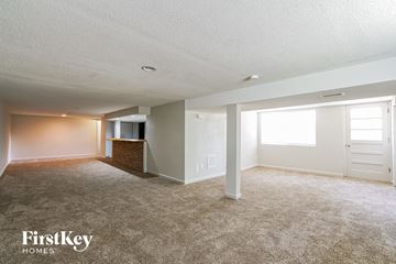 Saint Louis house for rent - a living room with carpet and a door to a kitchen