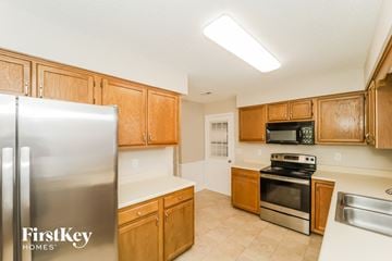 Greensboro house for rent - A kitchen with wooden cabinets and a stainless steel refrigerator.