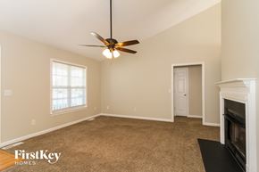 High Point house for rent - a living room with a fireplace and a ceiling fan