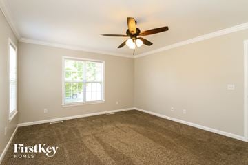 High Point house for rent - a living room with carpet and a ceiling fan