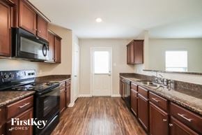 Cove house for rent - a kitchen with wooden floors and stainless steel appliances