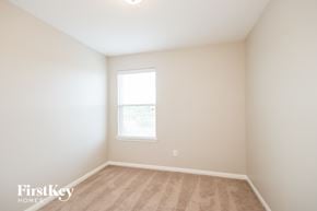 Cove house for rent - a bedroom with white walls and a window