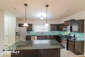 Newnan house for rent - a kitchen with dark wood cabinets and granite counter tops