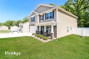 Lexington house for rent - a beige house with a lawn and a white fence