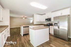 Lexington house for rent - a kitchen with white cabinets and stainless steel appliances