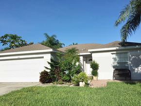 Bradenton house for rent - A white house with a brown roof and a garage door.
