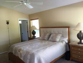 Bradenton house for rent - A bedroom with a bed, nightstand, and lamp.