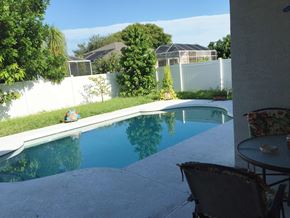 Bradenton house for rent - A person is sitting on a chair by a pool.